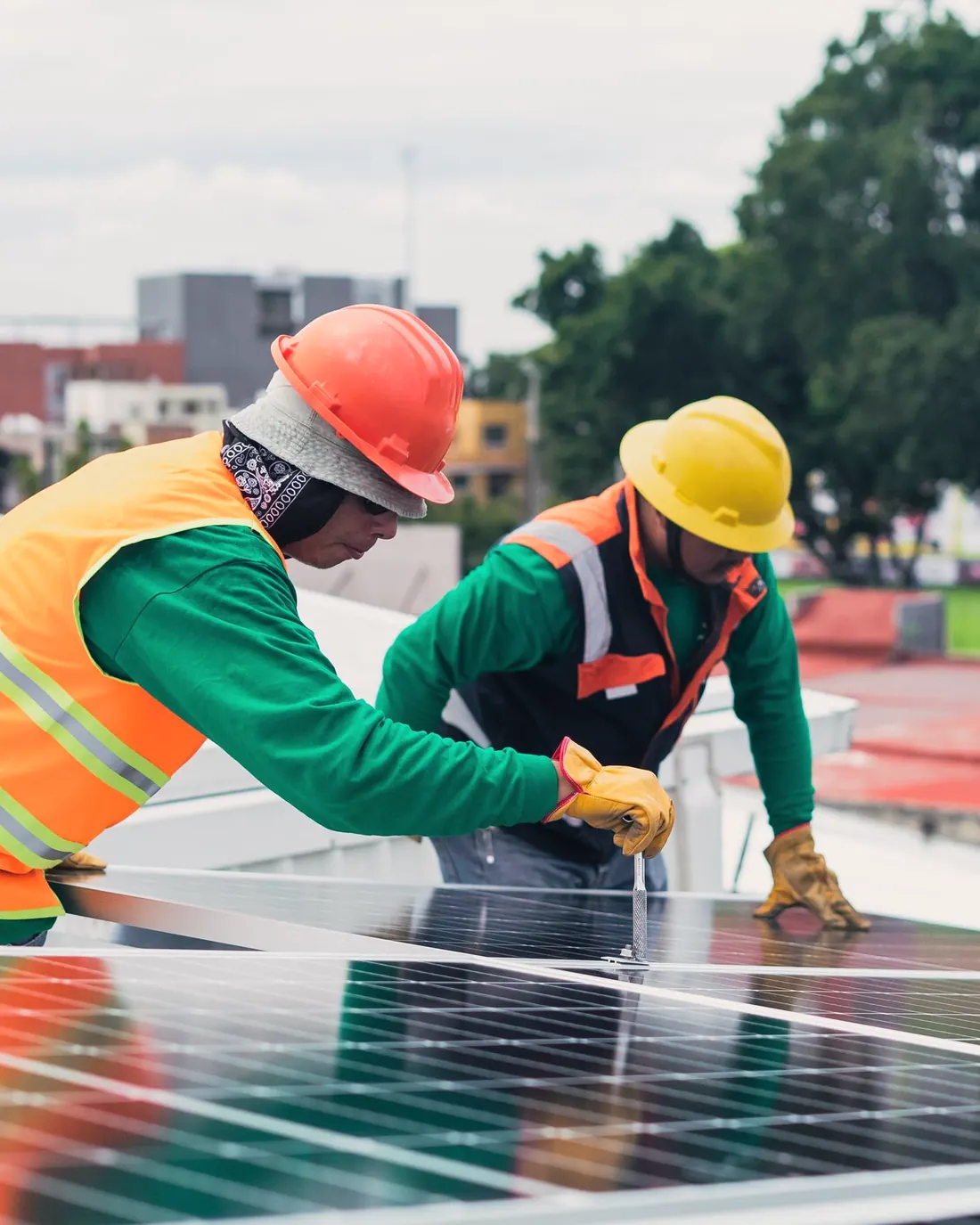 Two installers fitting solar panels on a sunny rooftop